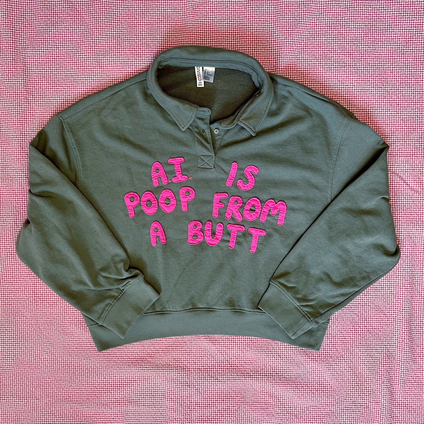 Army green pullover with bright pink letters