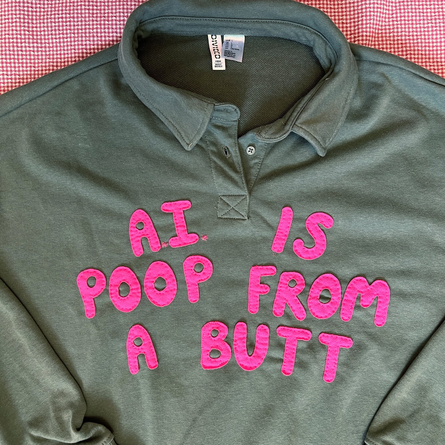 Army green pullover with bright pink letters