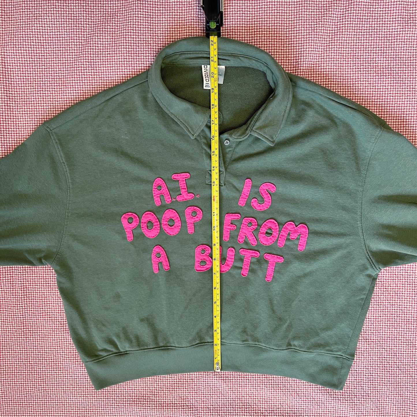 Army green pullover with bright pink letters