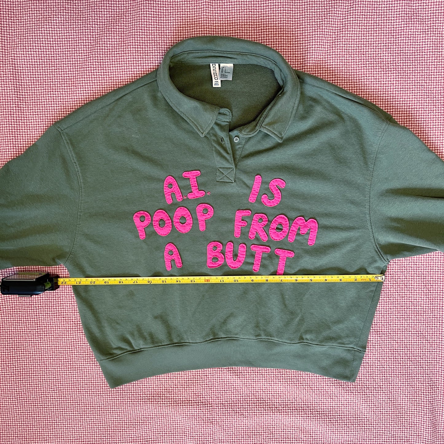 Army green pullover with bright pink letters