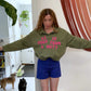 Army green pullover with bright pink letters